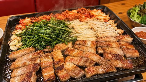 鉄板で焼ける厚切りの豚バラと、キムチ・豆苗・えのき・にんにく
