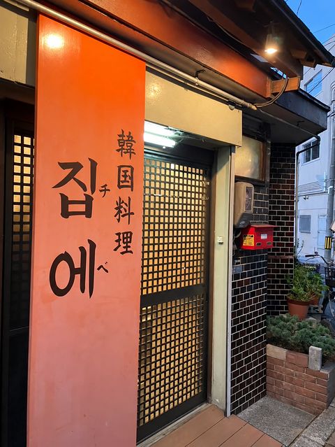 朱の看板と格子戸の入口